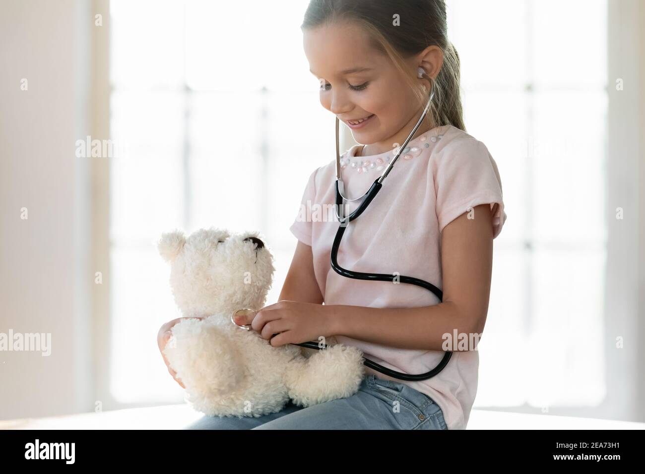 Carino bambina agire come medico con giocattolo Foto Stock