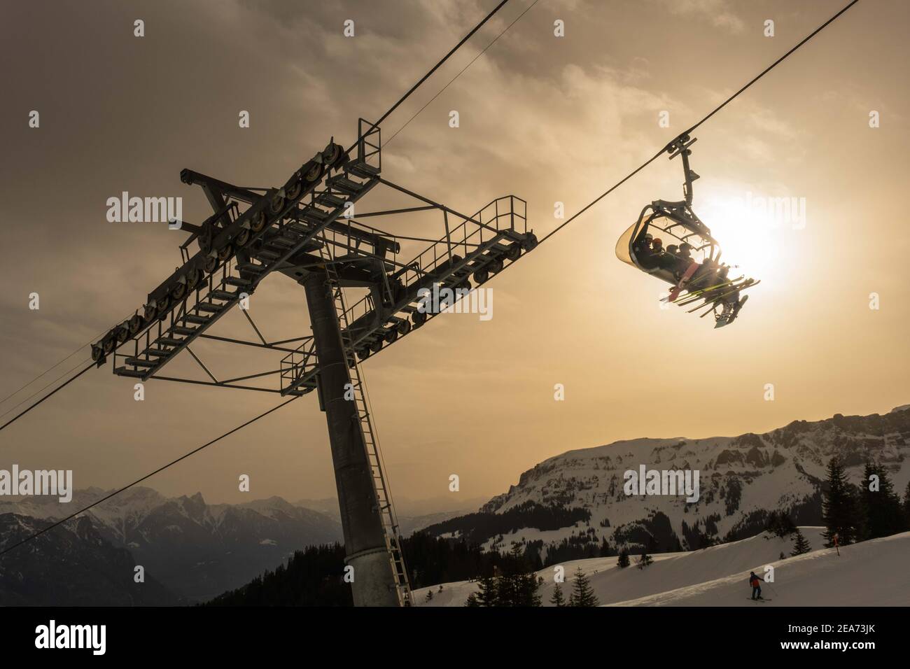 Sesselbahn in Skigebiet vor gelbem Saharastaub in den Schweizer Bergen Foto Stock