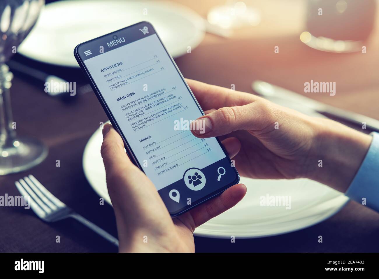persona che sceglie il cibo per la cena dal menu dell'app del telefono cellulare al ristorante Foto Stock