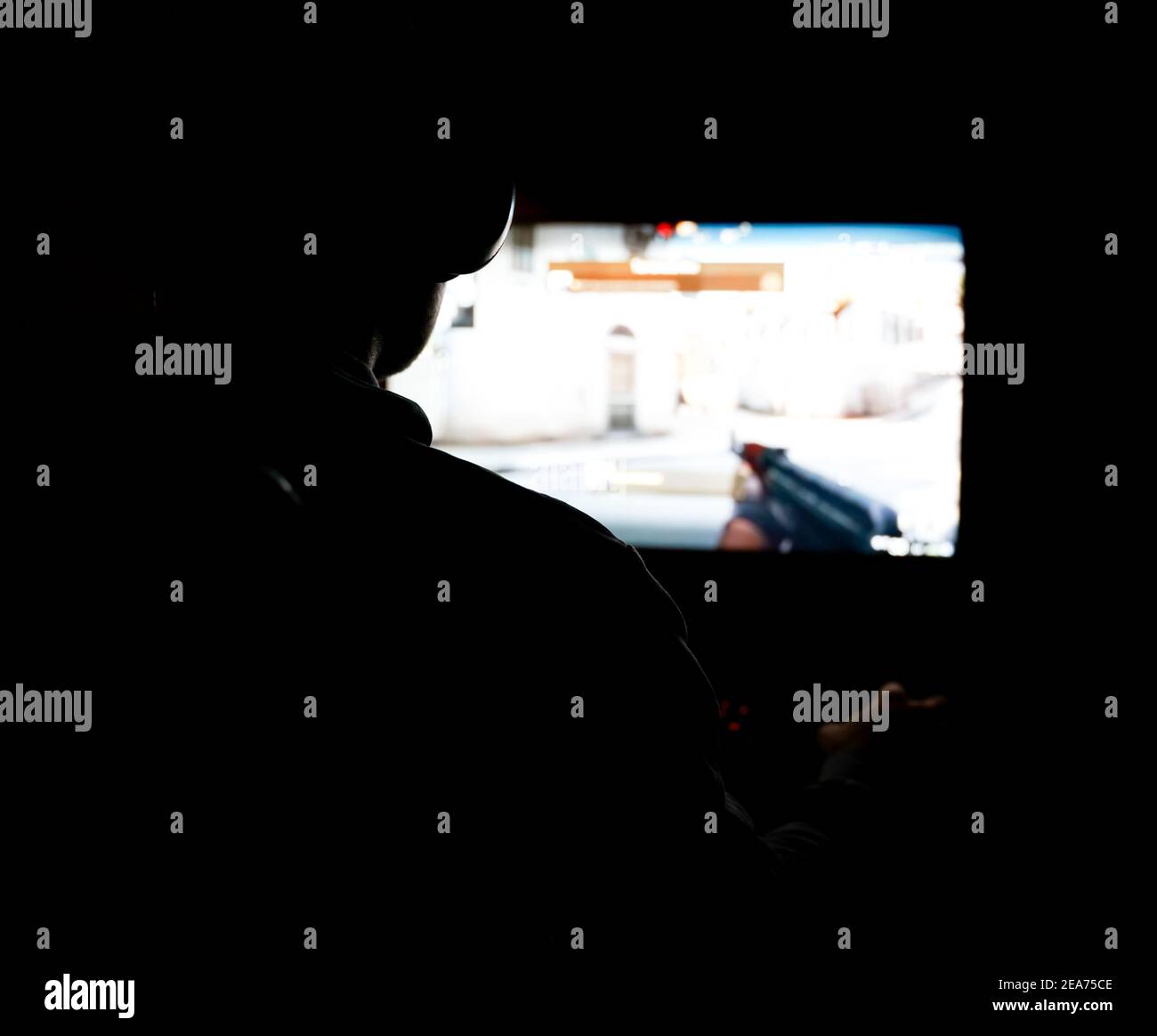 Silhouette di una persona che gioca un gioco sparatutto 3D su un computer. Foto Stock