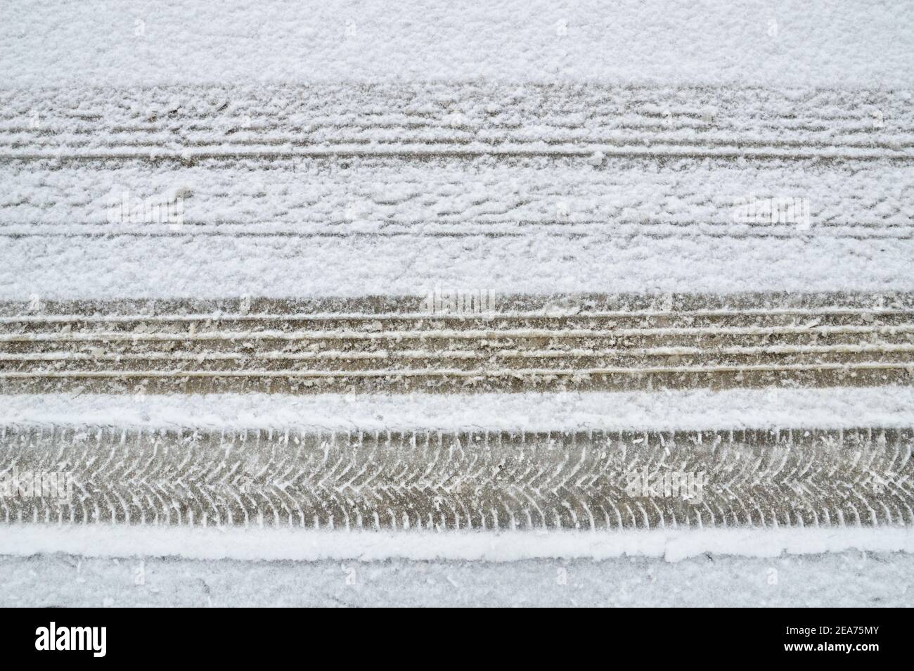 Differenza su una strada innevata tra uno pneumatico standard e. una ruota da neve con cingoli per pneumatici Foto Stock