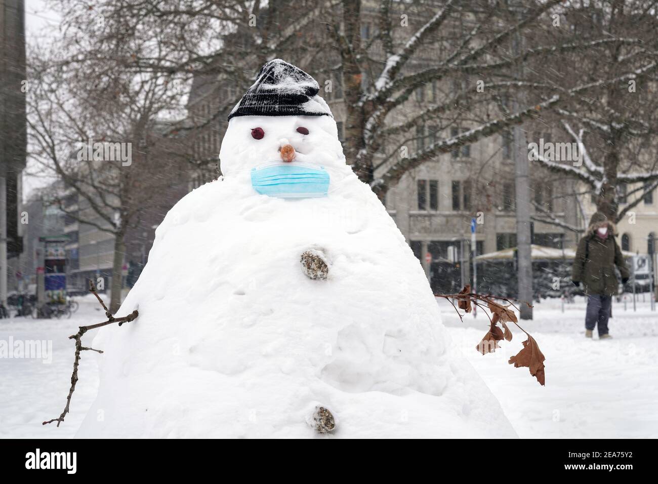 Hannover, 08.02.2021: Wintereinbruch in Norddeutschland, Schneemann mit einer medizinischen Maske auf dem Ernst-August-Platz in Hannover --- Hannover, 8 febbraio 2021: Inverno nella Germania del Nord, pupazzo di neve con maschera medica su Ernst-August-Platz ad Hannover, Germania Foto Stock