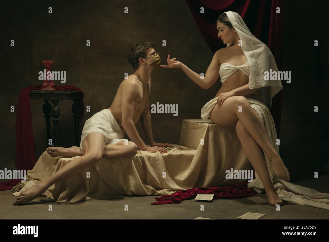 Niente baci con maschera dorata. Moderno remake di opere d'arte classiche con tema coronavirus - giovane coppia medievale su sfondo scuro, di colore dorato. Concetto di coronavirus, pandemia, creatività. Foto Stock