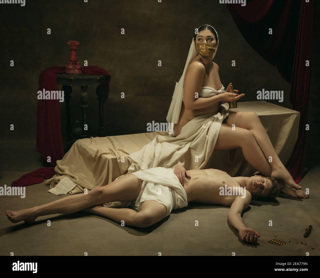 Lavate le mani con l'igienizzatore. Moderno remake di opere d'arte classiche con tema coronavirus - giovane coppia medievale su sfondo scuro, di colore dorato. Concetto di coronavirus, pandemia, creatività. Foto Stock