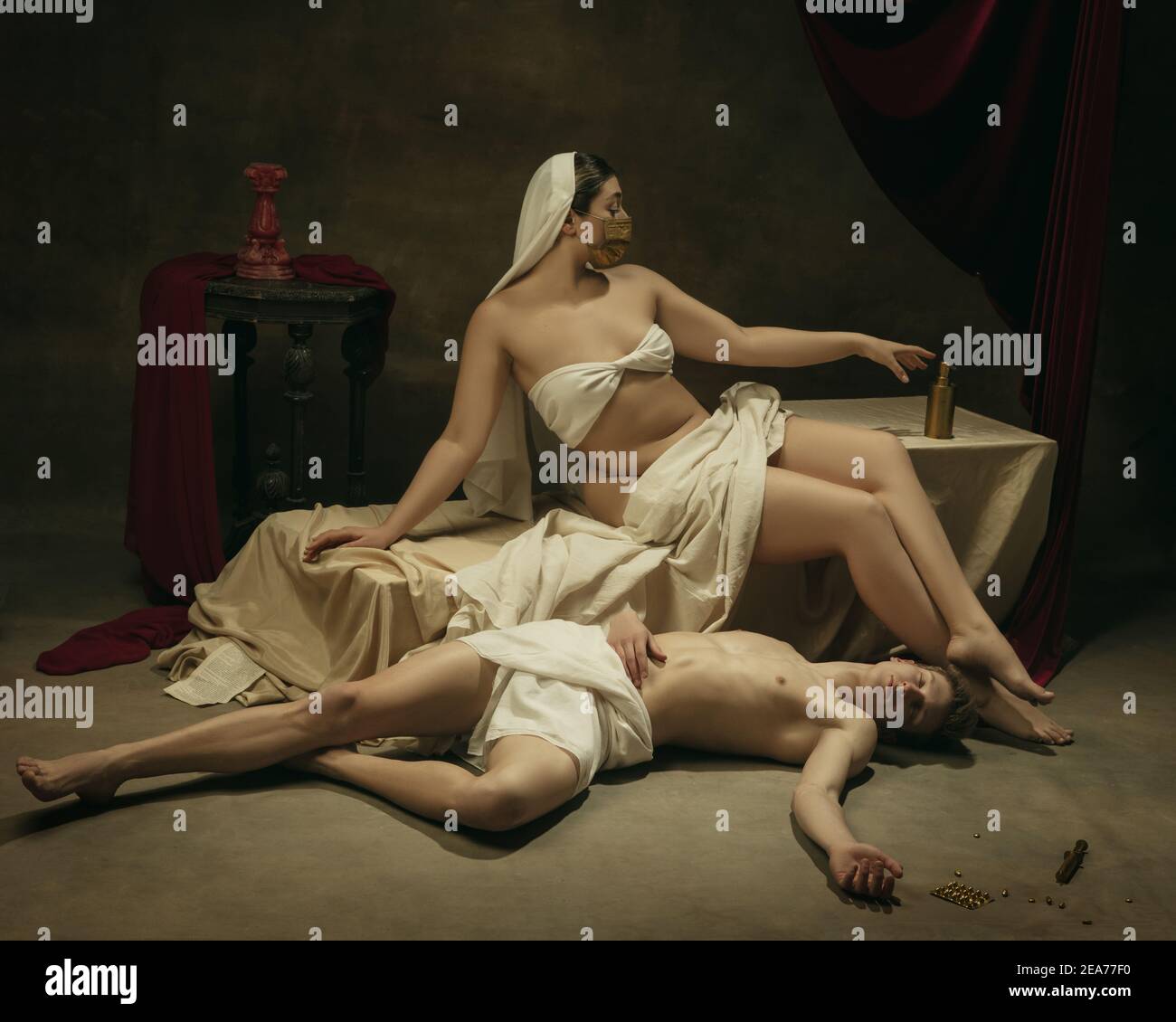 Lavate le mani con l'igienizzatore. Moderno remake di opere d'arte classiche con tema coronavirus - giovane coppia medievale su sfondo scuro, di colore dorato. Concetto di coronavirus, pandemia, creatività. Foto Stock