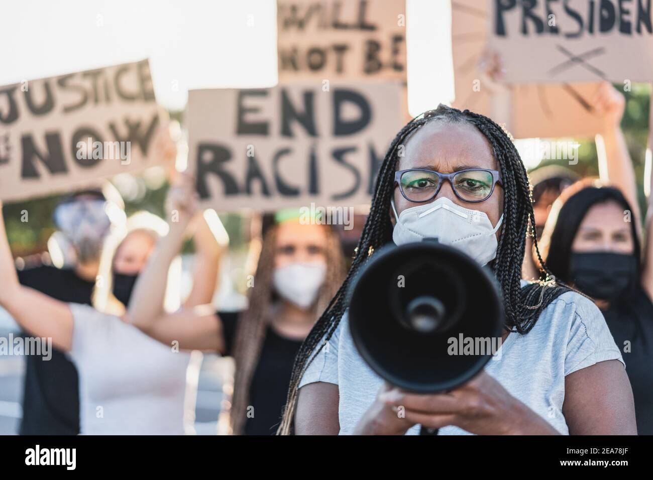 Gruppo di manifestanti su strada da culture diverse protestano per Pari diritti - Focus sulla donna anziana africana Foto Stock