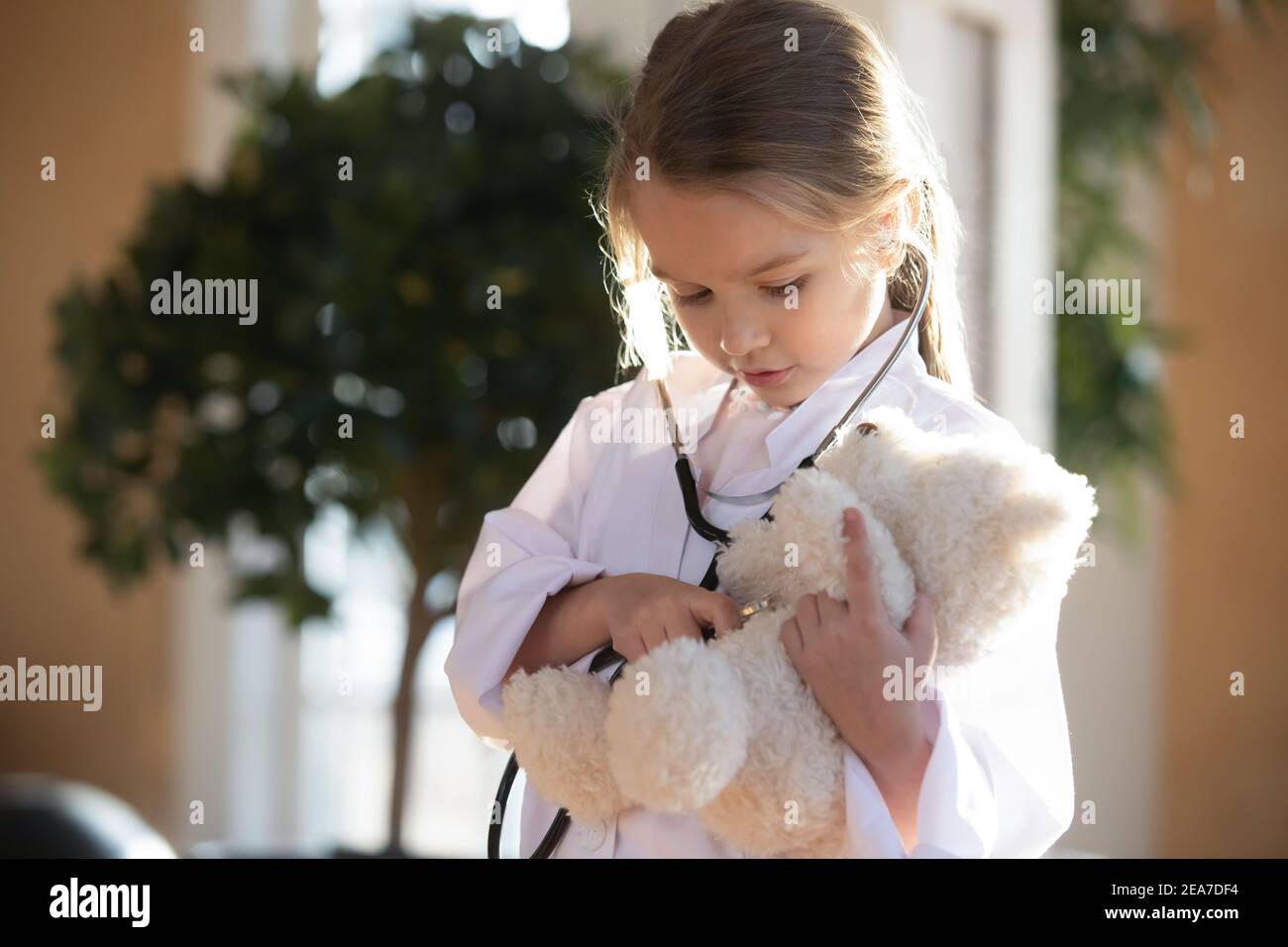 Bambina bambino agire come medico cura orsacchiotto Foto Stock
