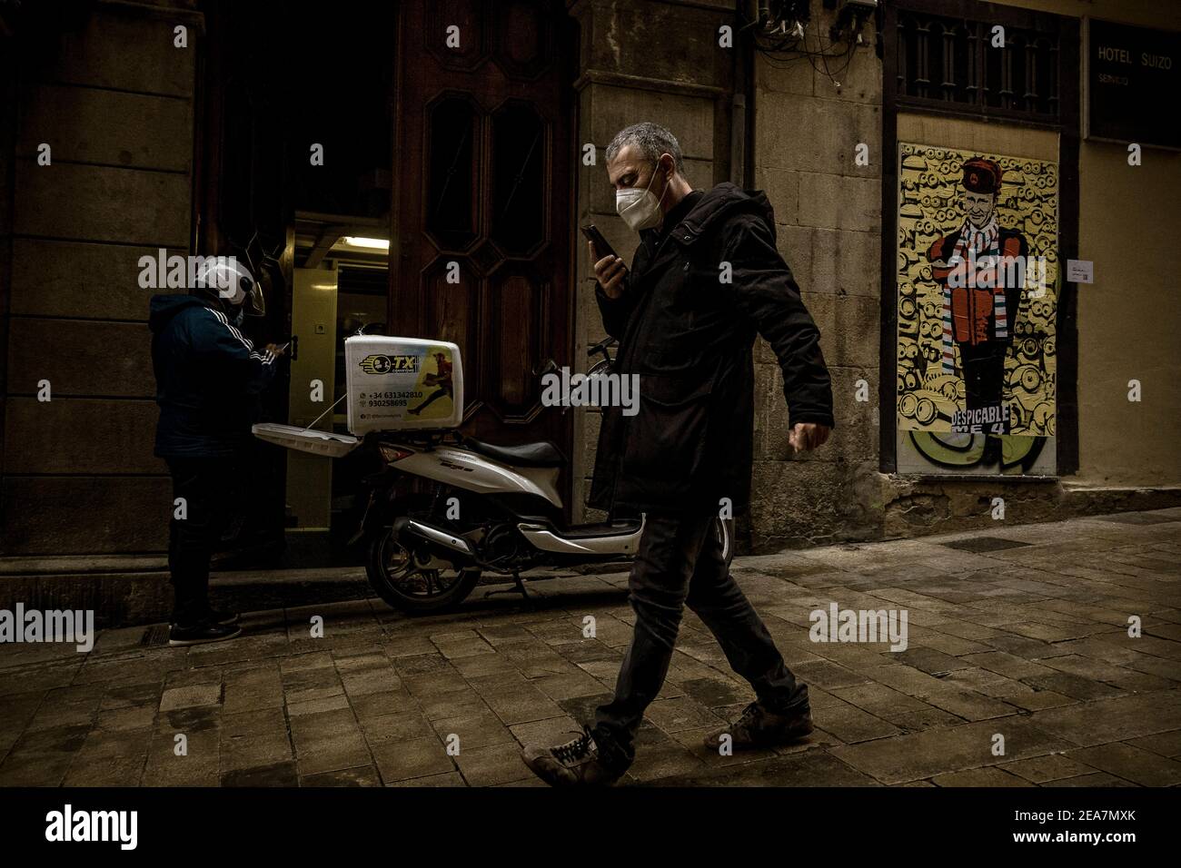 Barcellona, Spagna. 8 Feb 2021. Un commuter passa davanti a un nuovo graffito dell'artista urbano italiano "TVBoy", Salvatore Benintende, dal titolo "Spicable Me 4" e prende il nome da una famosa serie di film con il presidente russo Vladimir Putin di fronte ai minions Credit: Matthias Oesterle/Alamy Live News Foto Stock