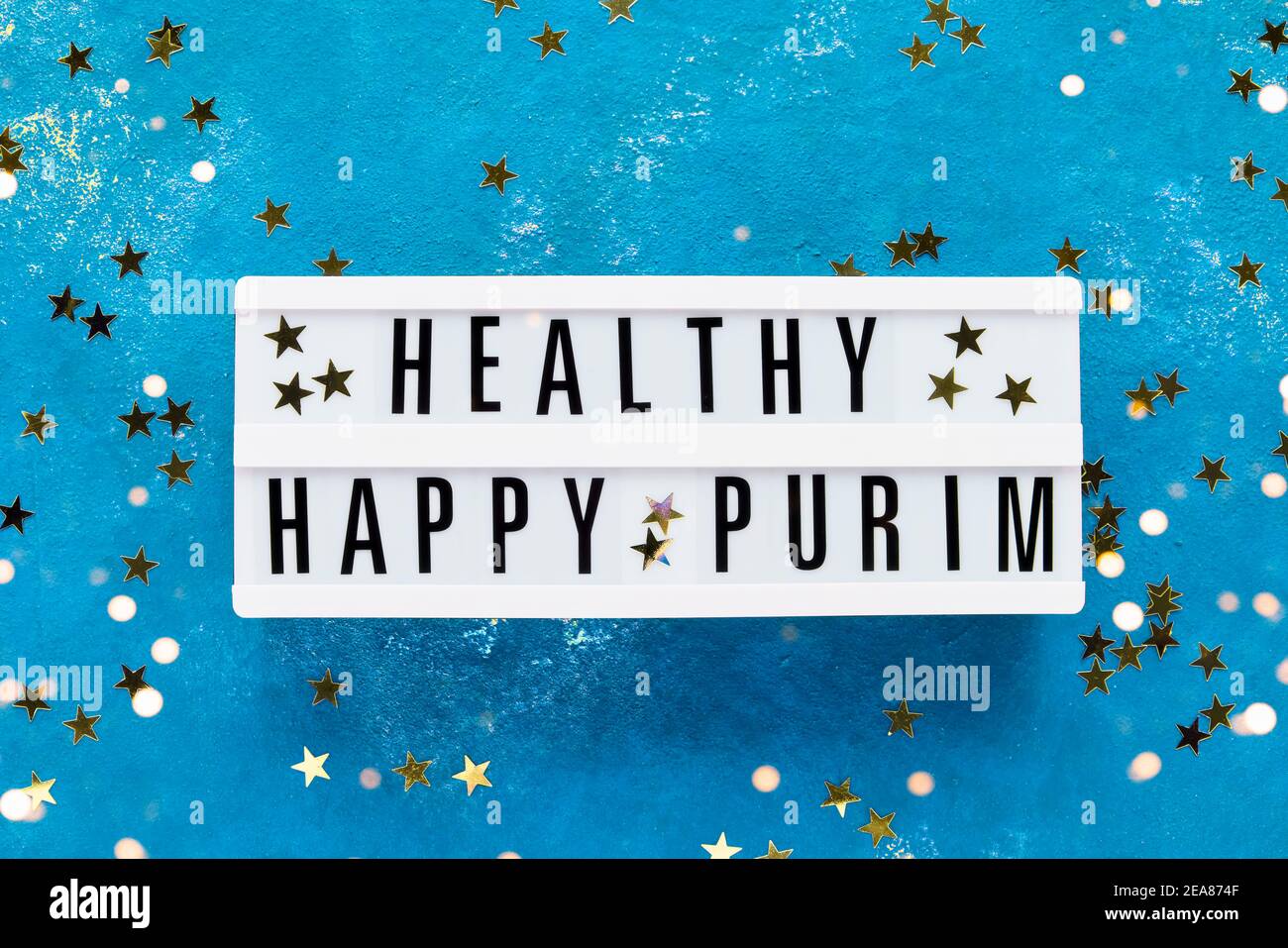 Concetto di celebrazione Purim. Purim sano scritto in scatola di luce su uno sfondo blu luminoso. Vista dall'alto, spazio di copia. Foto Stock