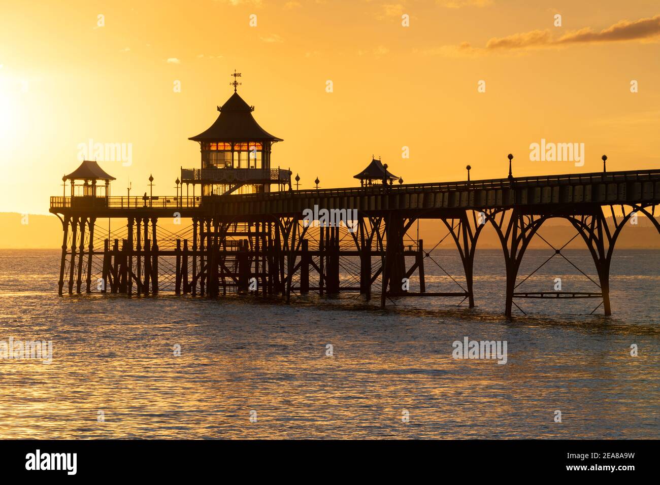 Clevedon Pier splendidamente retroilluminato con un tramonto dorato Foto Stock