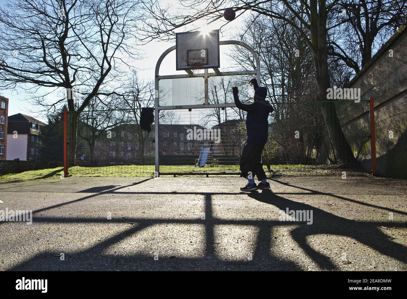 Giovane uomo che gioca a basket da solo Foto Stock