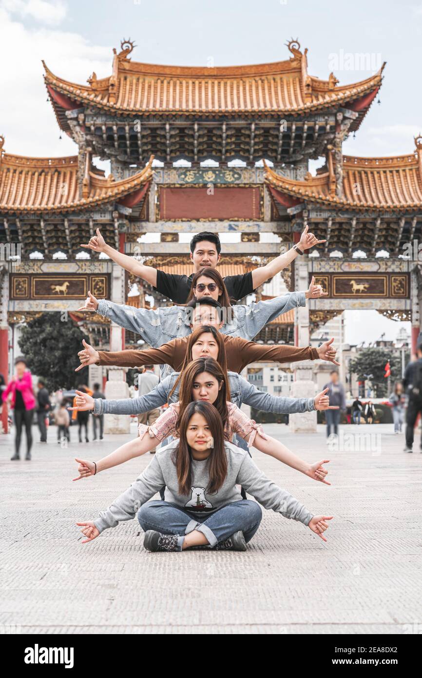 Azione di gruppo di amicizia asiatica sulla piazza Kunming Jinbi, Kunming, Cina, viaggi e turismo con nave amico, danza e parodia con copertura Foto Stock