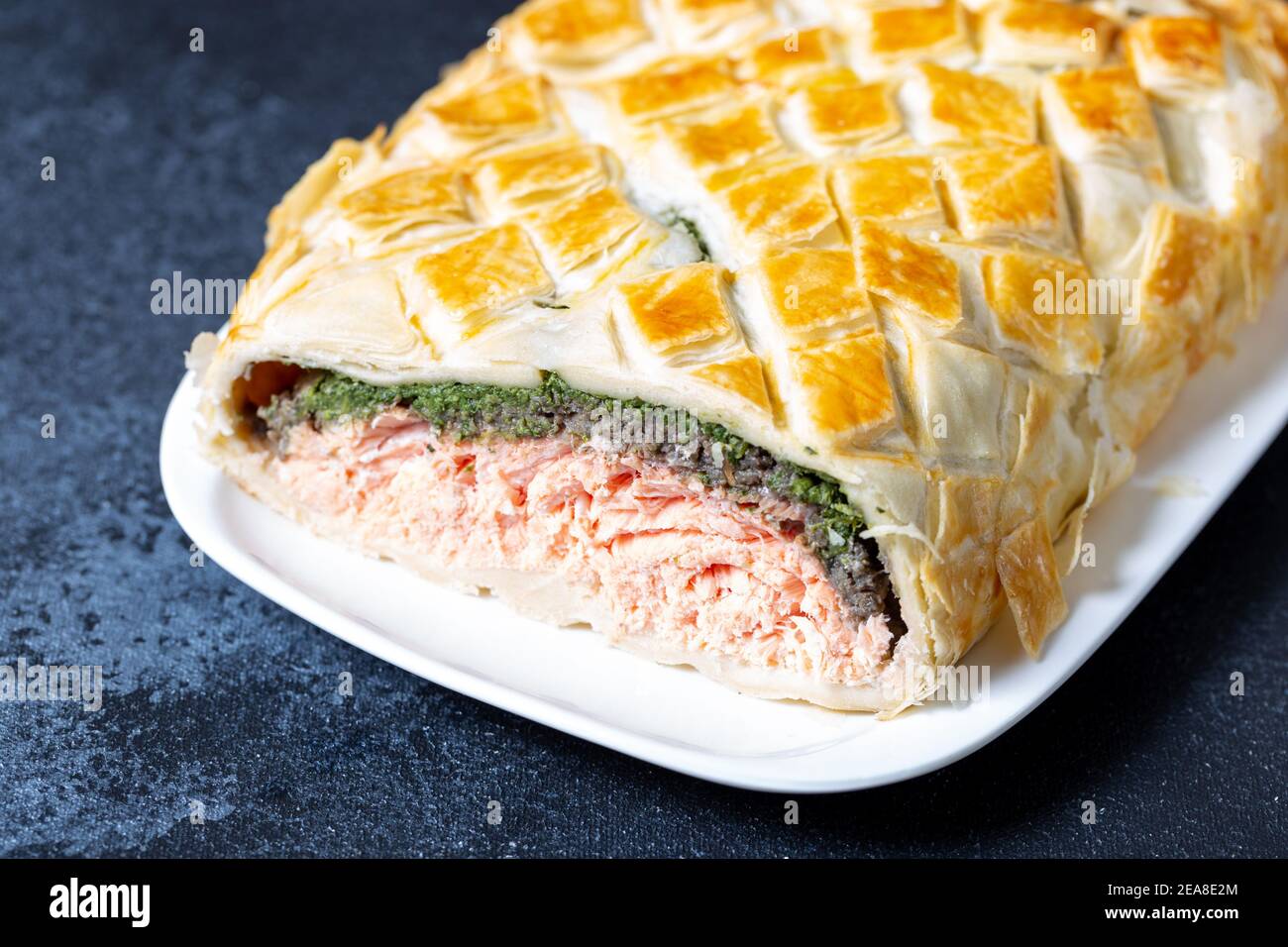 Wellington al salmone fatto in casa. E' composto da pesce salmone, spinaci, funghi, spezie, erbe e pasta sfoglia. Spazio di copia Foto Stock