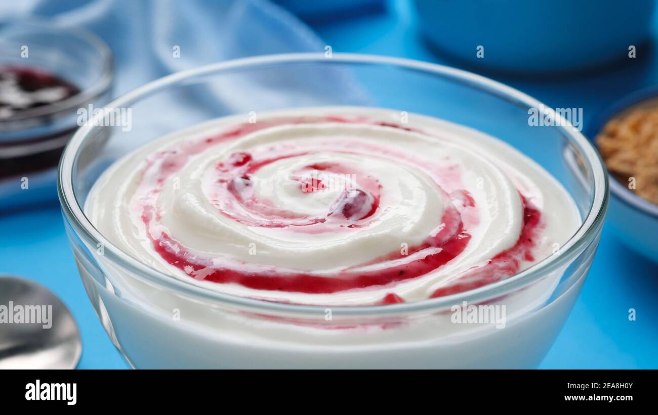 Yogurt con marmellata di frutti di bosco, panna montata al mirtillo Foto Stock