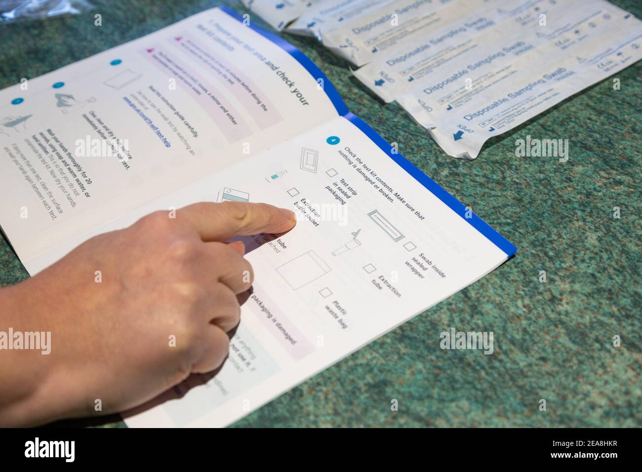Ashford, Kent, Regno Unito. 8 Feb 2021. Una donna segue le istruzioni per un corredo domestico di auto-test di Covid 19, test del coronavirus. Photo Credit: PAL Media/Alamy Live News Foto Stock