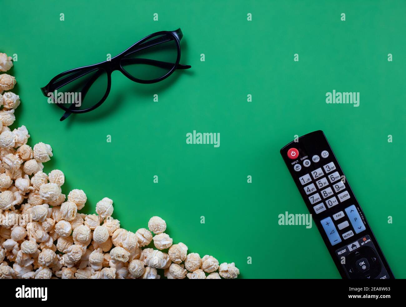 Telecomando TV con popcorn al formaggio e 3 bicchieri D sullo sfondo della  chiave cromatica verde