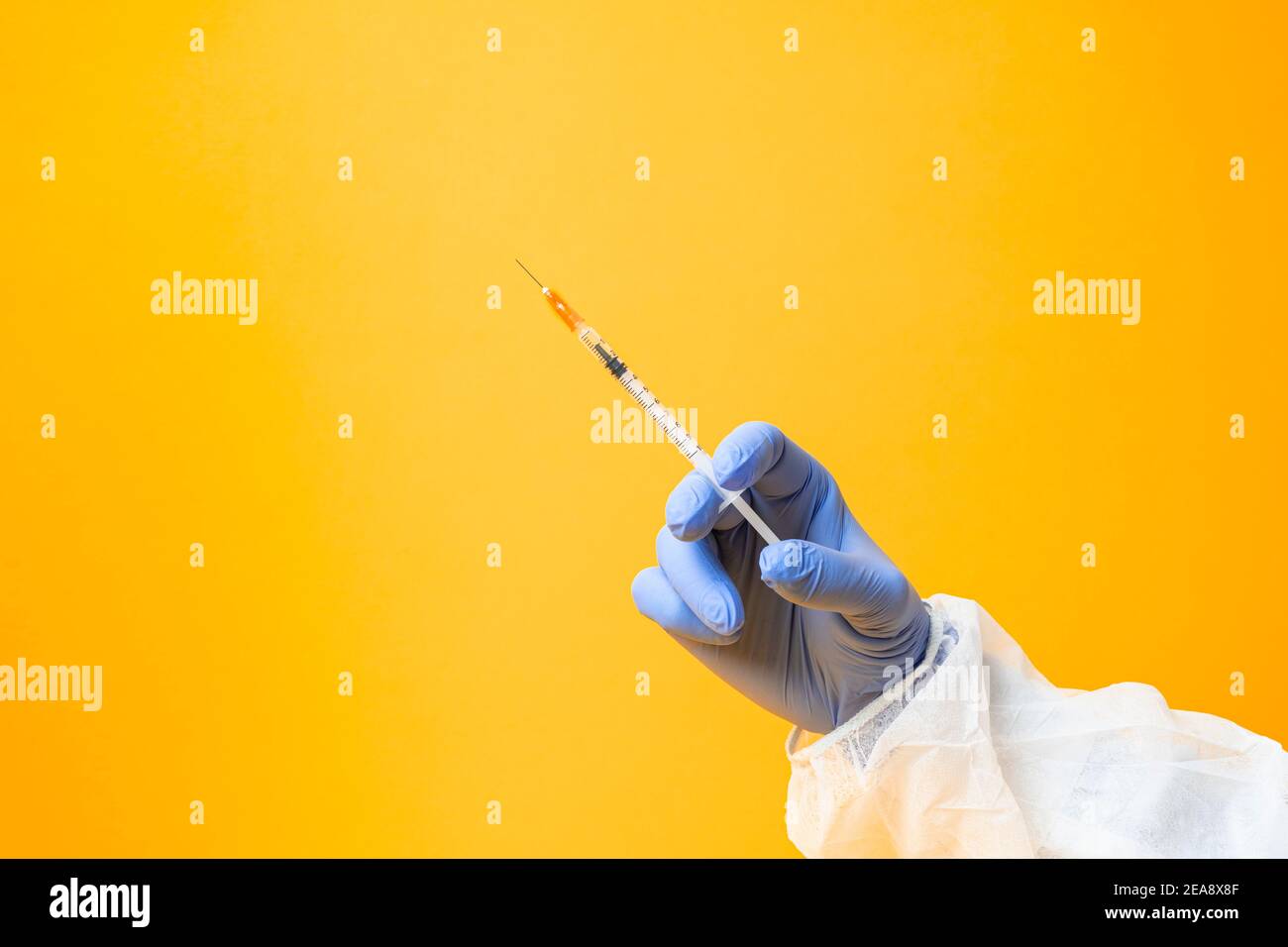 Laboratorio mani in guanti medici trattamento vaccino ricerca su a. sfondo giallo Foto Stock