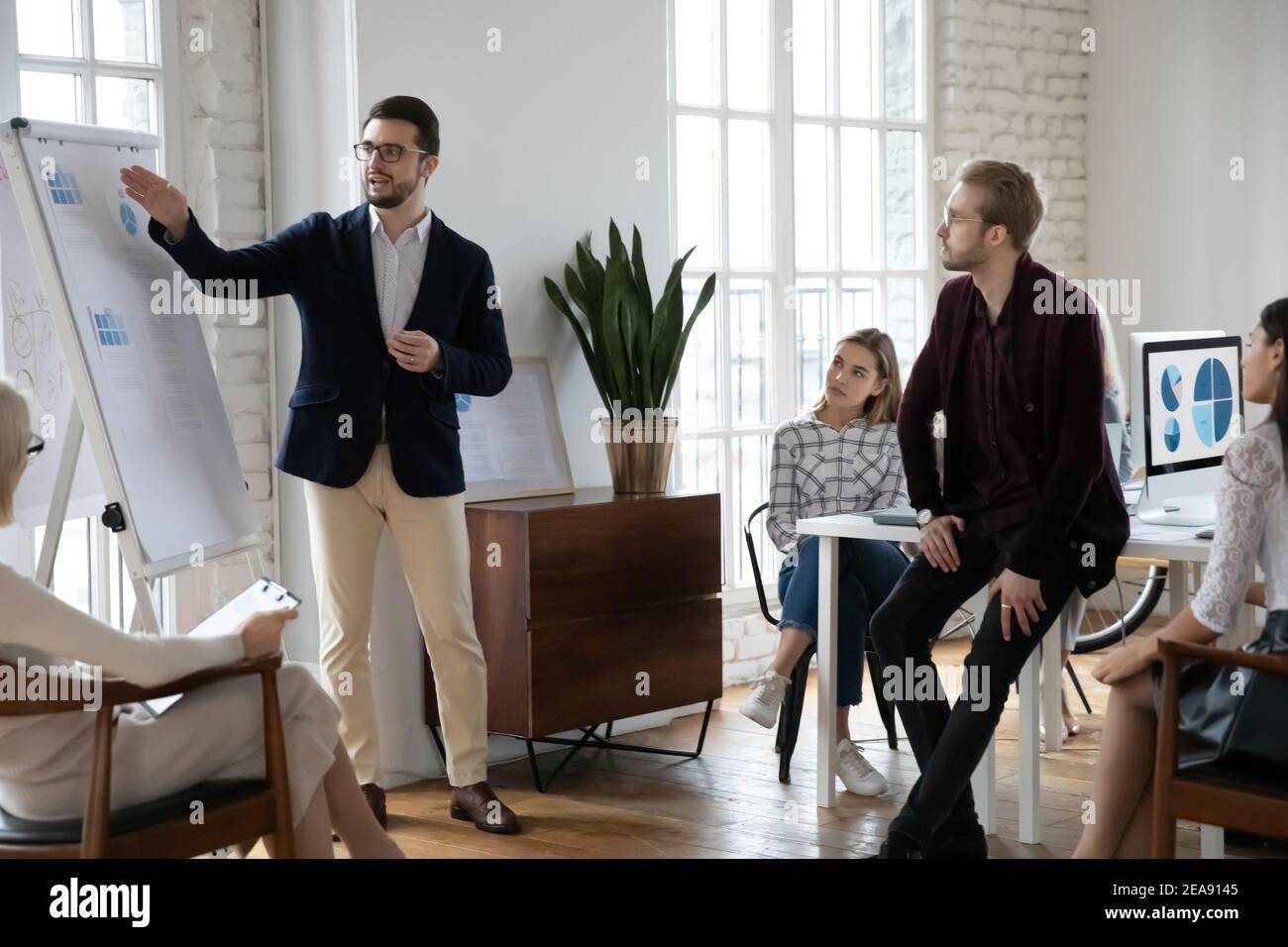 Leader e team di startup che analizzano la ricerca di marketing durante la riunione aziendale Foto Stock