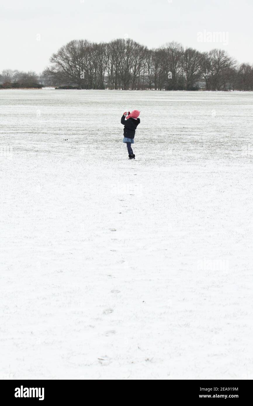 Una giovane ragazza cammina lungo un Wanstead Park innevato. La neve e il ghiaccio pesanti hanno portato disagi in alcune parti del Regno Unito, con Londra che riceve circa 5 cm di neve. I forti venti orientali di Storm Darcy hanno precipitato le temperature in alcune parti del Regno Unito a meno di uno. Foto Stock