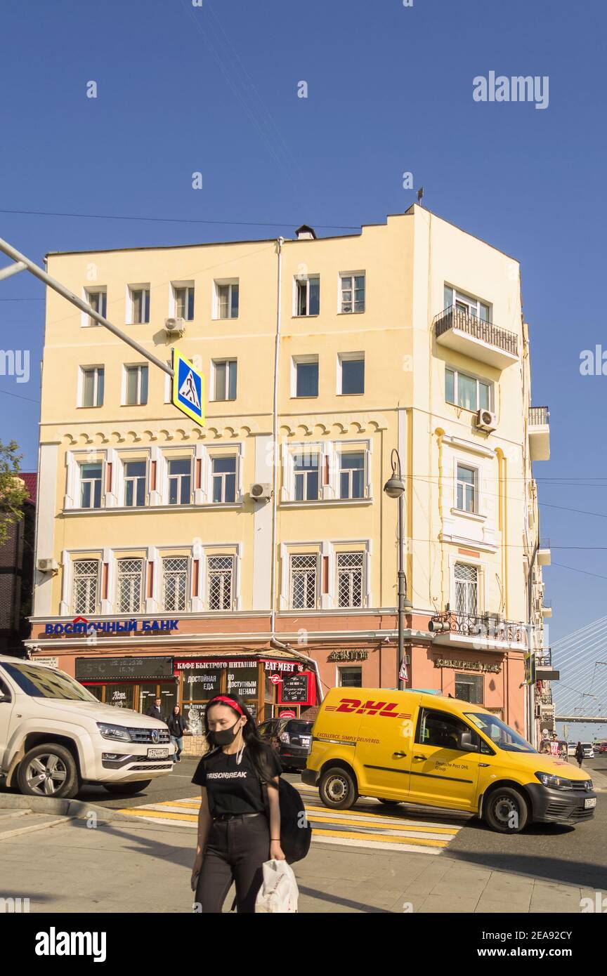 Vladivostok, Russia - 08 ottobre 2020: Vista della strada trafficata con persone che camminano auto in movimento e DHL auto girare a destra Foto Stock