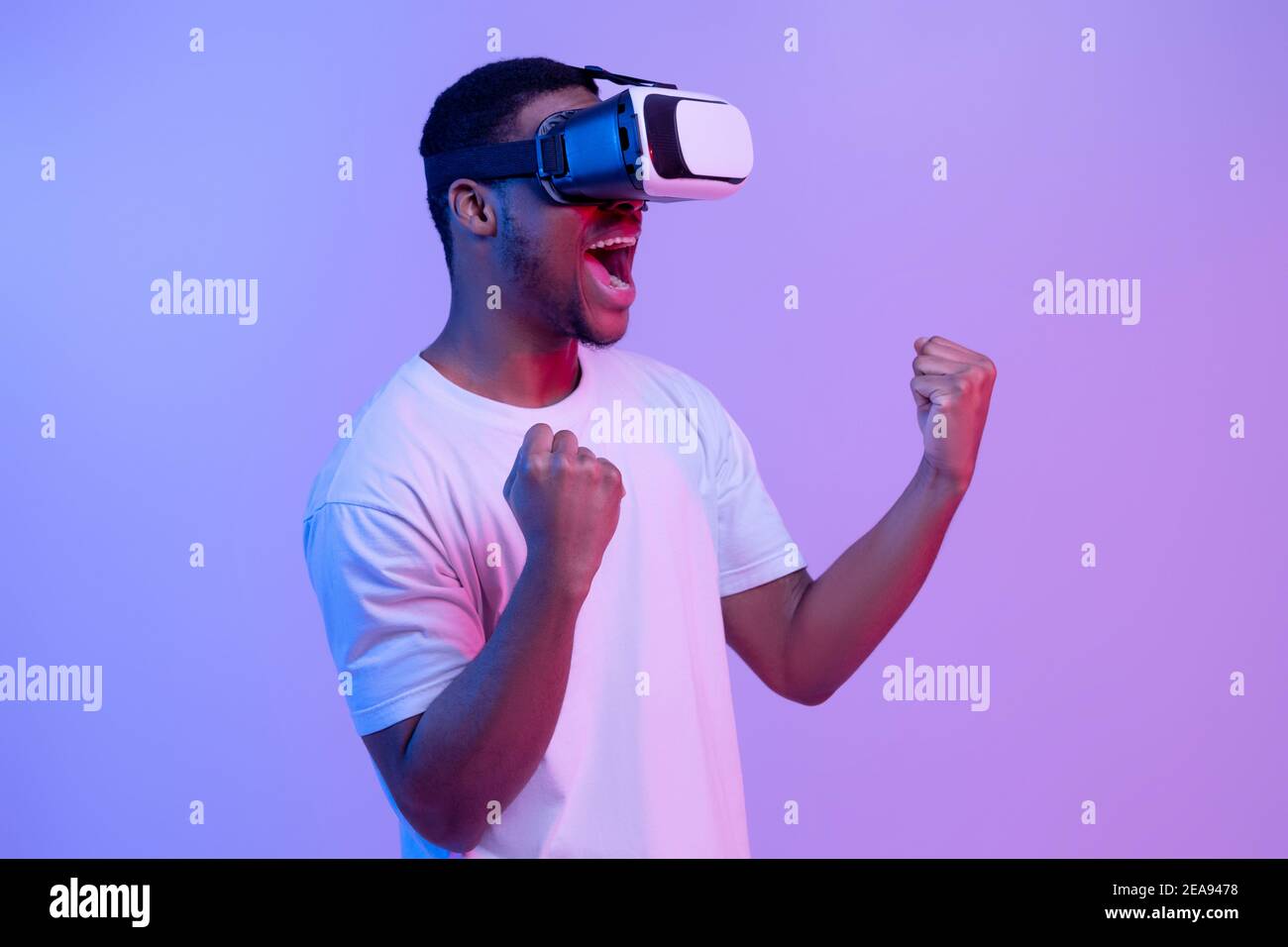 Occhiali da visore VR: L'uomo nero eccitato gioca ai Cyber Games, Neon Light Foto Stock