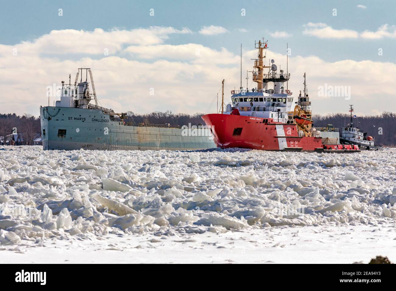 Roberts Landing, Michigan, Stati Uniti. 7 Feb 2021. La Guardia Costiera canadese Samuel Risley e la Guardia Costiera americana Cutter Bristol Bay lavorano insieme per rompere il ghiaccio sul fiume St. Clair. Il freddo amaro ha portato alle marmellate di ghiaccio sul fiume e alle inondazioni nelle comunità costiere. Il fiume St. Clair è il confine tra gli Stati Uniti e il Canada; scolo i grandi laghi superiori verso il lago St. Clair e sul lago Erie. Credit: Jim West/Alamy Live News Foto Stock