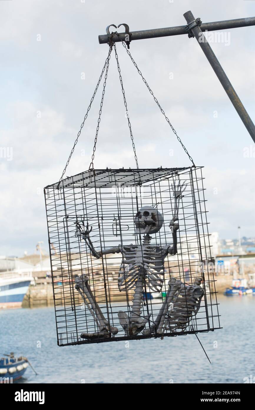 Uno scheletro umano artificiale e gabbiato che domina il porto interno di Brixham. Brixham ha una grande flotta da pesca, è popolare tra i turisti ed è ospite di una p Foto Stock