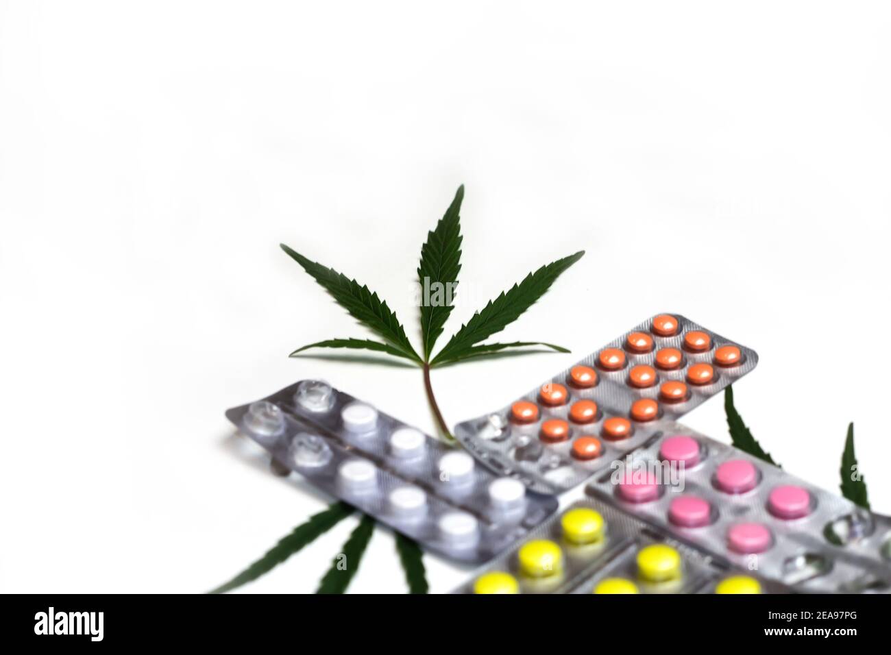 Foglia di marijuana e pillole mediche su sfondo bianco moderno alla moda Minimalismo stile concetto di medicina alternativa pillole colorate in blister sopra bianco Foto Stock