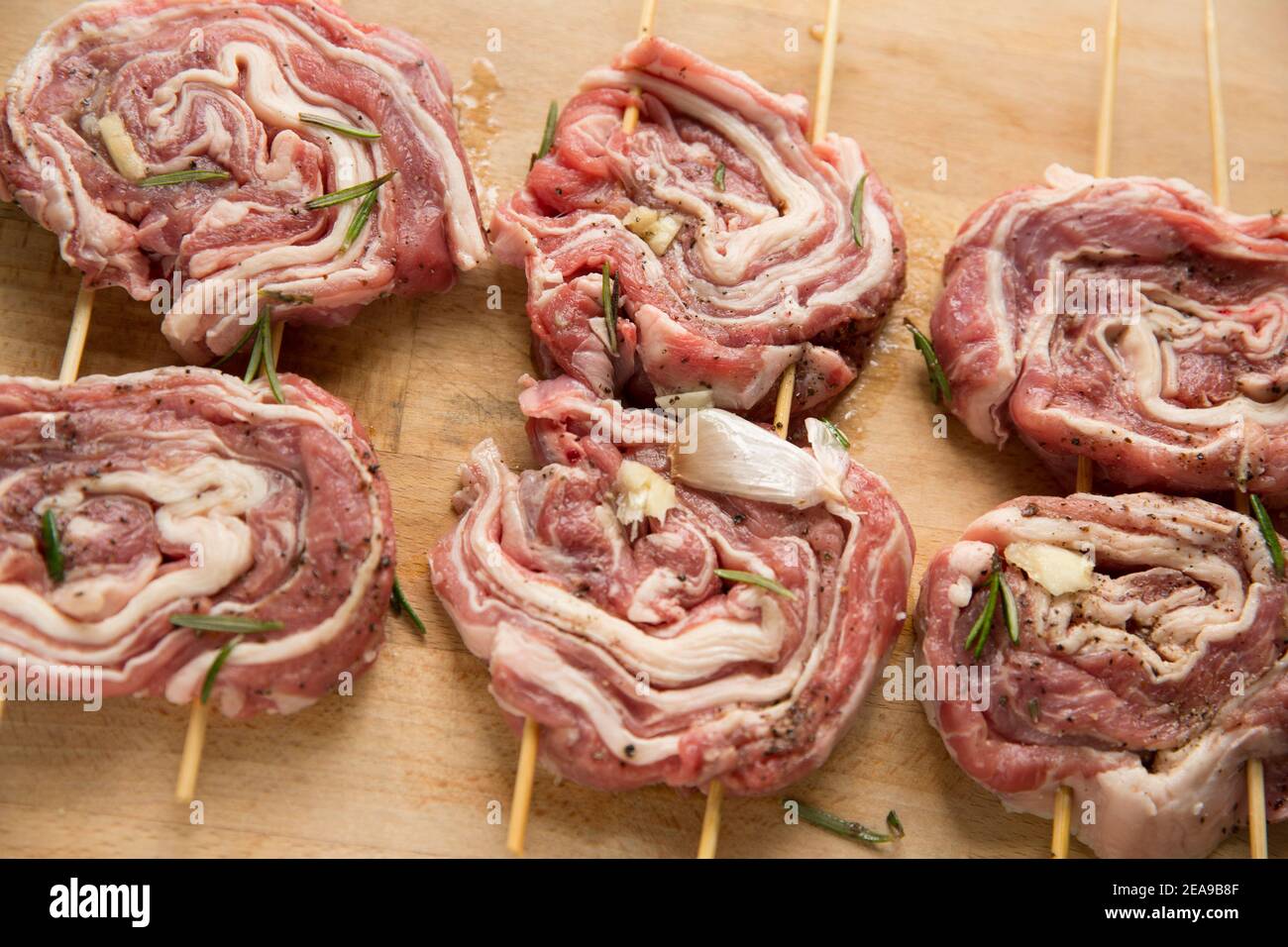 Agnello britannico crudo, arrotolato, che è stato marinato in olio d'oliva, rosmarino e aglio per la cottura alla griglia a casa. Inghilterra Regno Unito GB Foto Stock