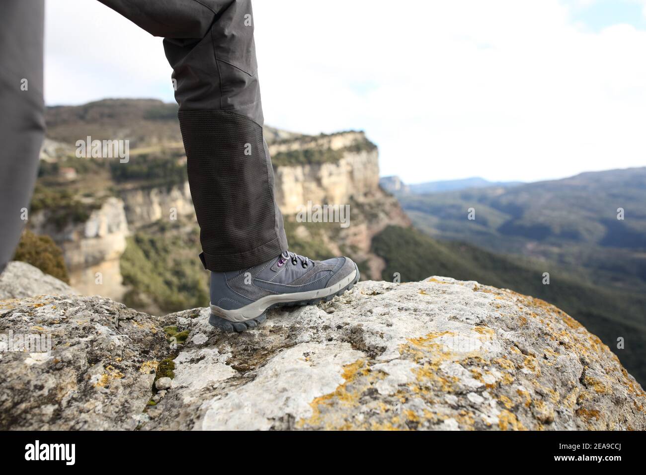 Primo piano di uno scarpone da trekking nella parte superiore di una scogliera in montagna Foto Stock