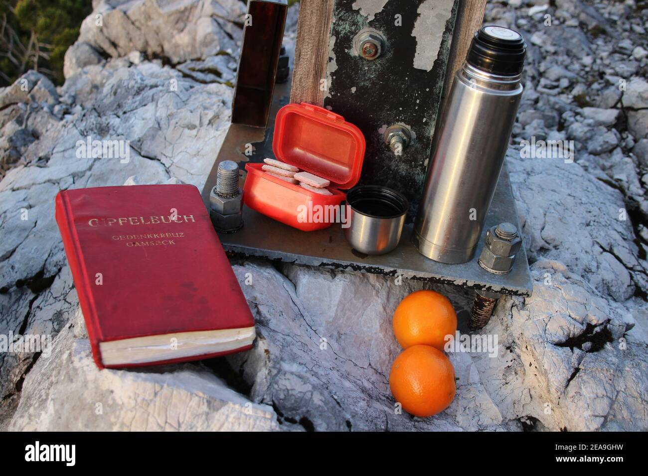 Gamseck sopra il rifugio Mittenwalder, croce commemorativa, libro sommitale, snack, thermos, arance Foto Stock