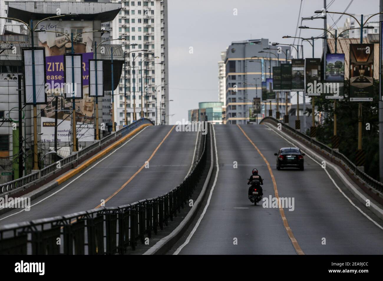 Un'autostrada con solo pochi veicoli sono visti durante la quarantena comunità aumentata a Manila, Filippine. Foto Stock