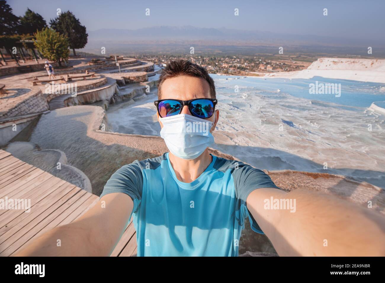 L'uomo in una maschera medica è arrivato in una popolare attrazione turistica in Turchia - Pamukkale e scattando foto selfie. Escursioni e tour durante il Coronavir Foto Stock