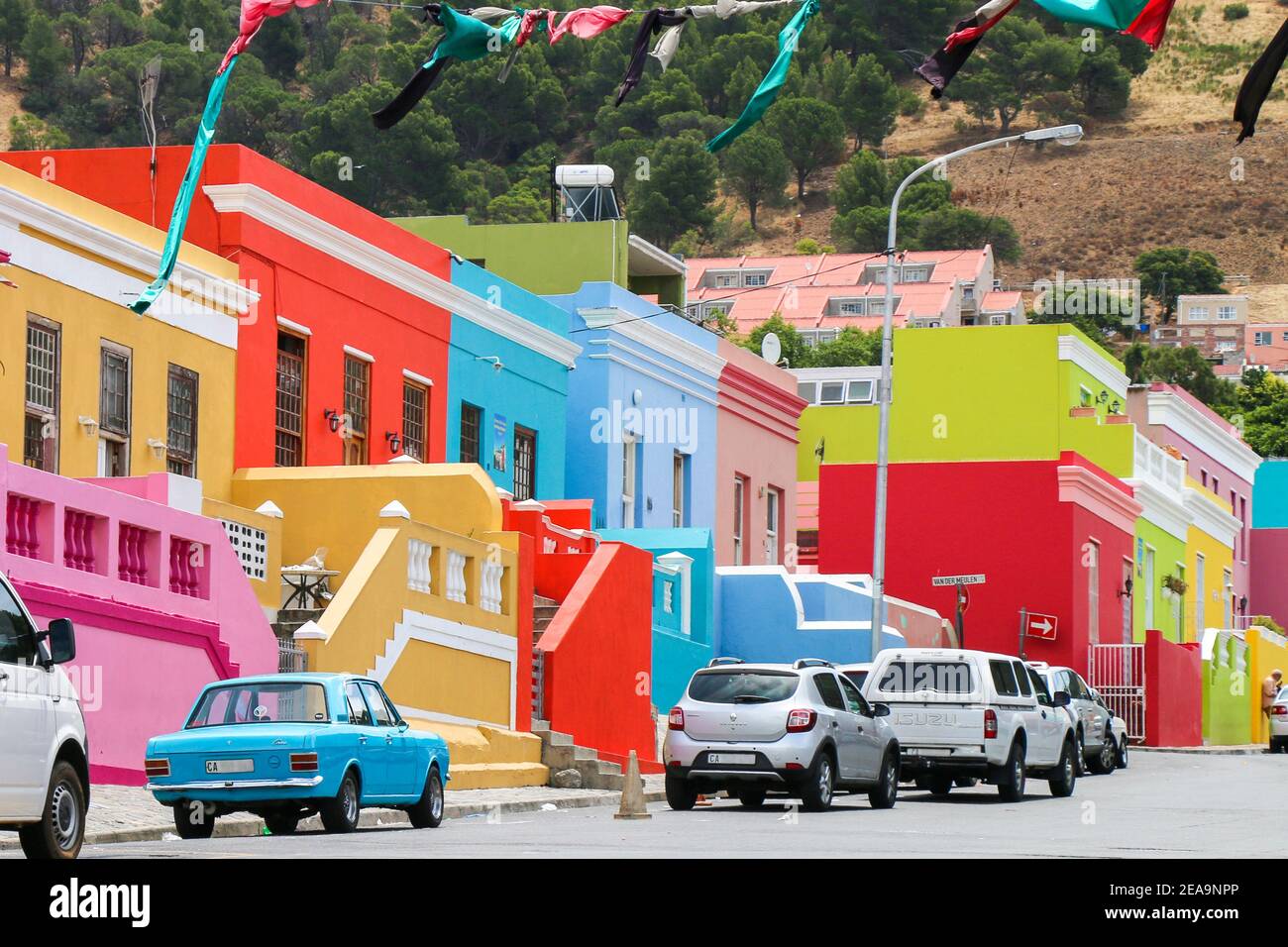 Belle case multicolore a Città del Capo, Sud Africa con classica auto vintage blu di fronte Foto Stock