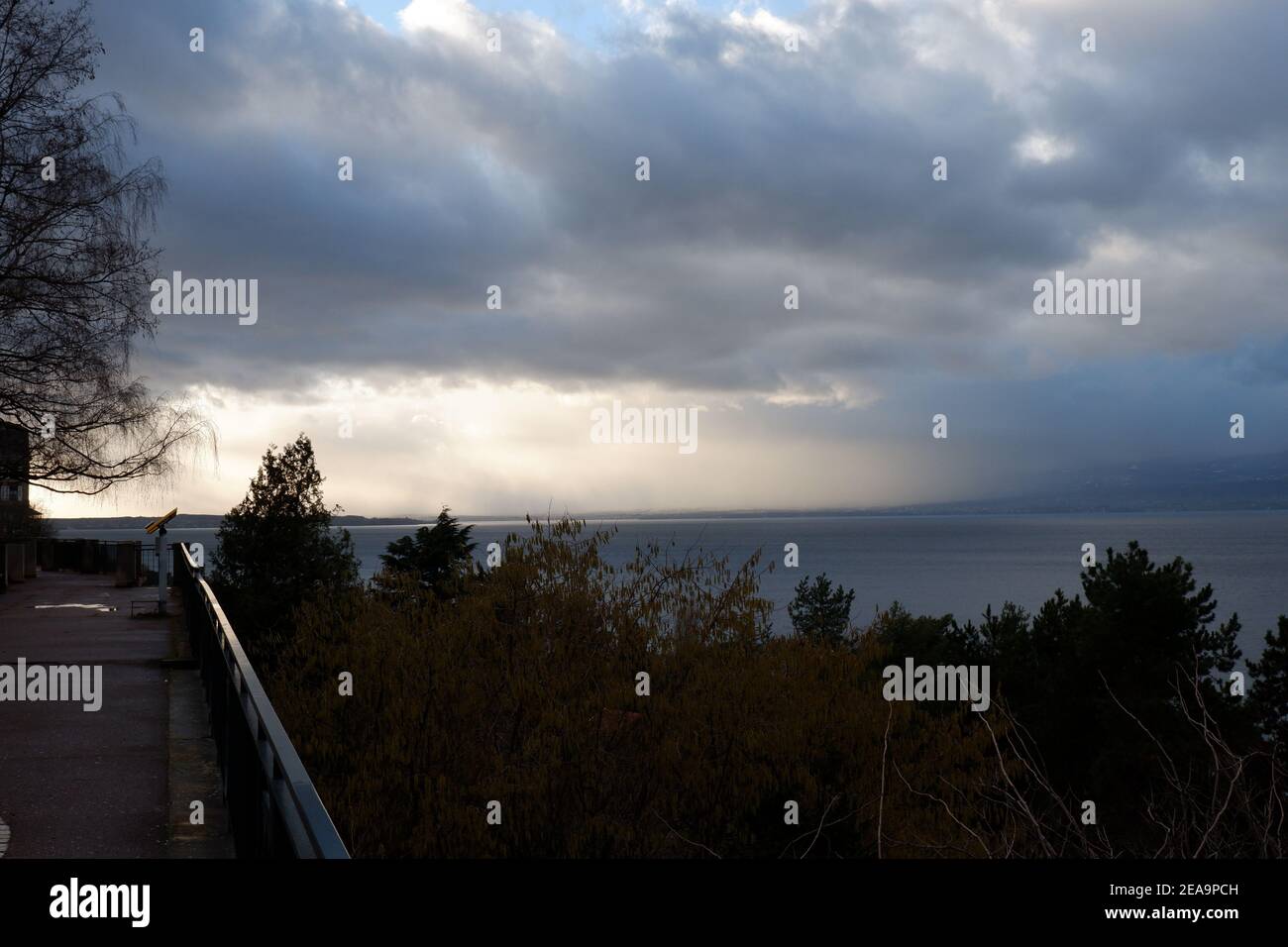 Il sole del pomeriggio che brucia attraverso le nuvole salvasa il lago. Foto Stock
