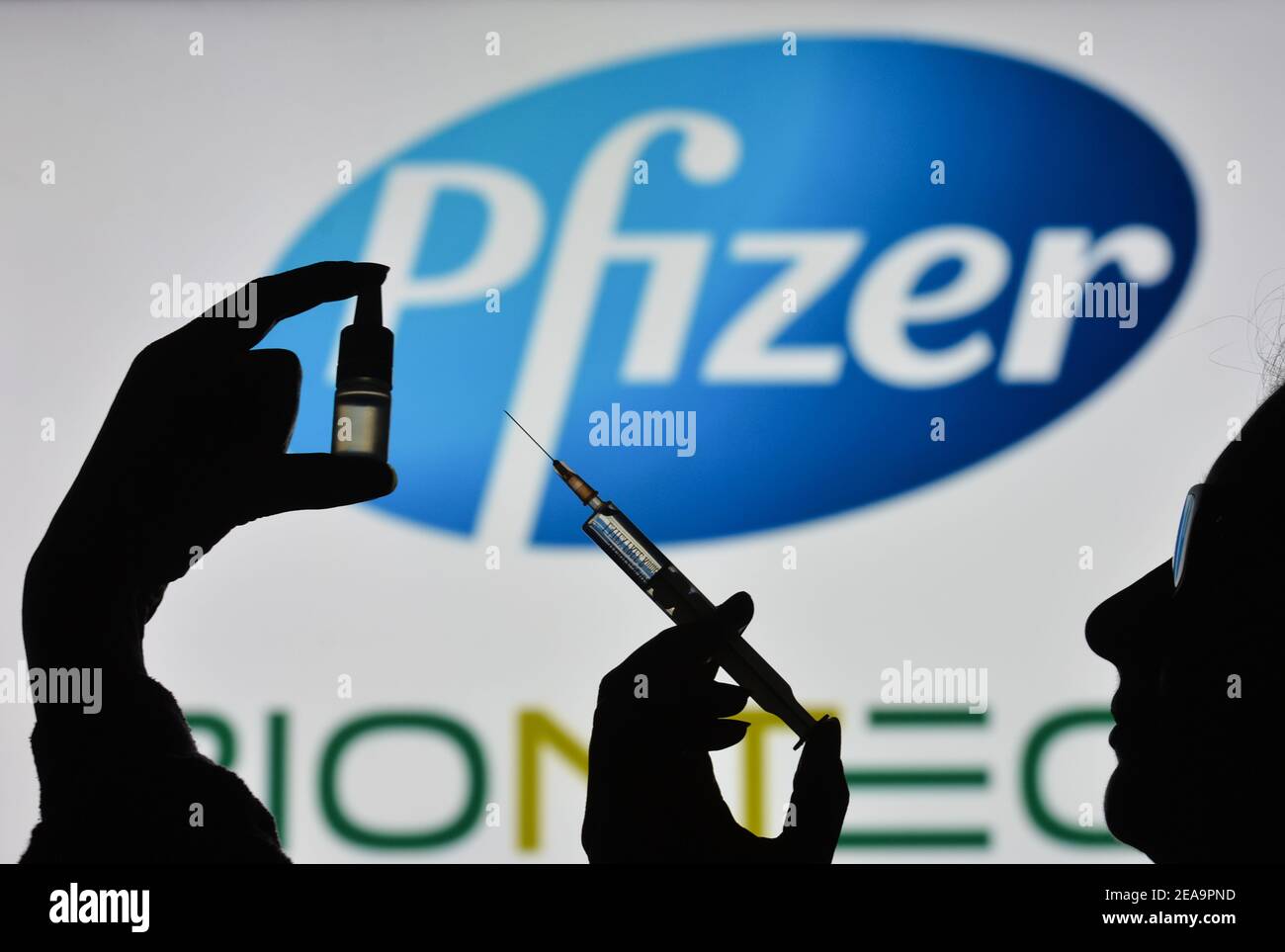 Irlanda. 7 Feb 2021. In questa illustrazione fotografica una silhouette di un uomo che tiene una siringa medica e un flaconcino visto davanti al logo Pfizer su uno schermo. Credit: Cezary Kowalski/SOPA Images/ZUMA Wire/Alamy Live News Foto Stock