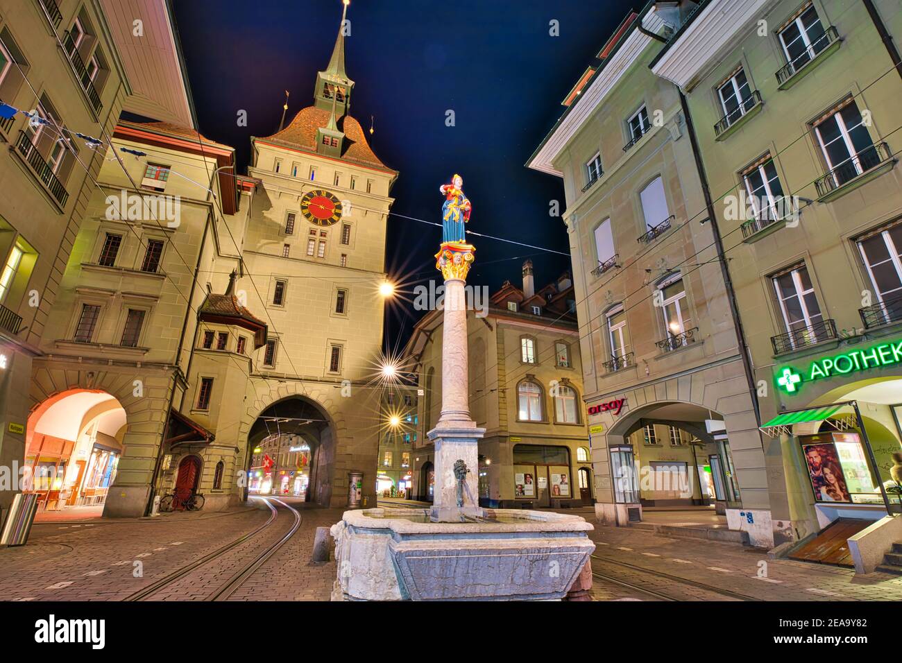 Berna, Svizzera - 23 agosto 2020: Scena urbana notturna della torre Kafigturm, una torre di guardia medievale e la fontana Anna Seiler in via Marktgasse. UNESCO Foto Stock