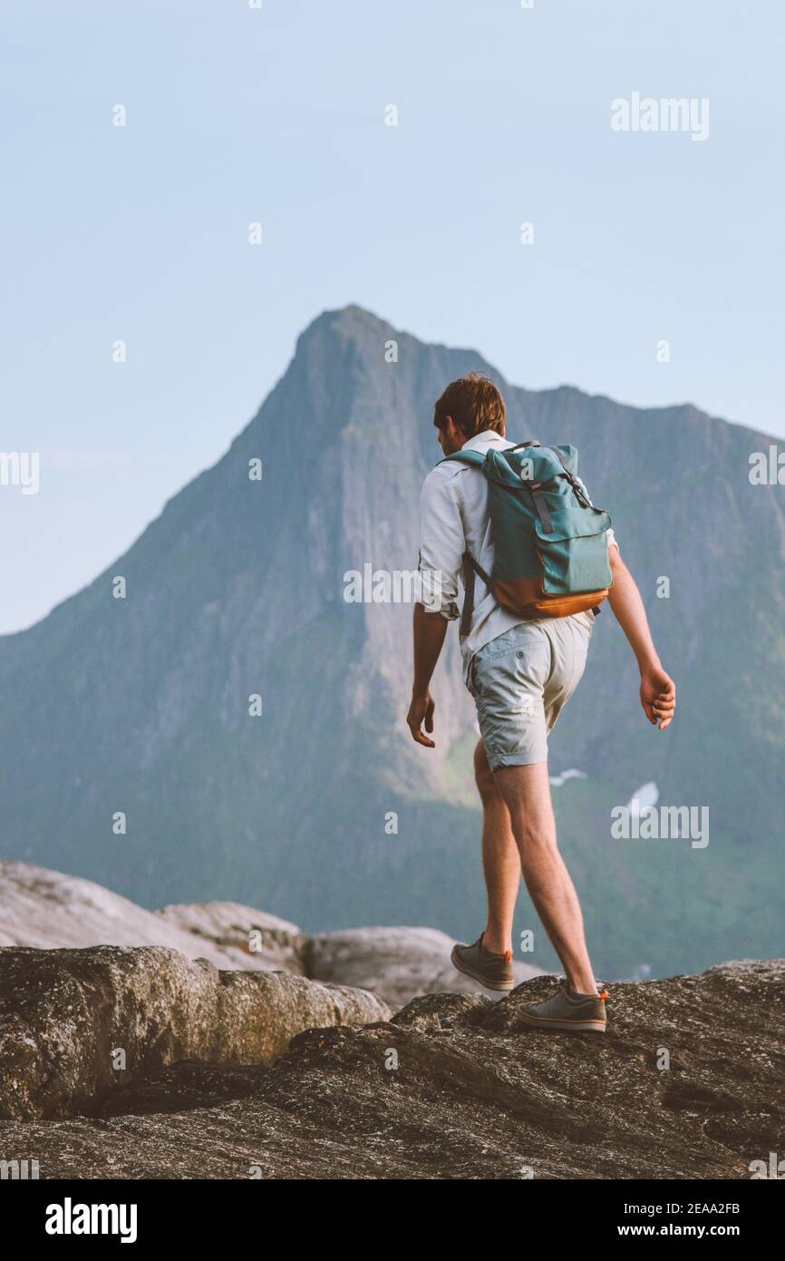 Uomo escursionismo viaggiare da solo in Norvegia vacanze backpacking eco turismo in montagna avventura all'aperto attivo stile di vita sano abbigliamento estivo pantaloncini Foto Stock