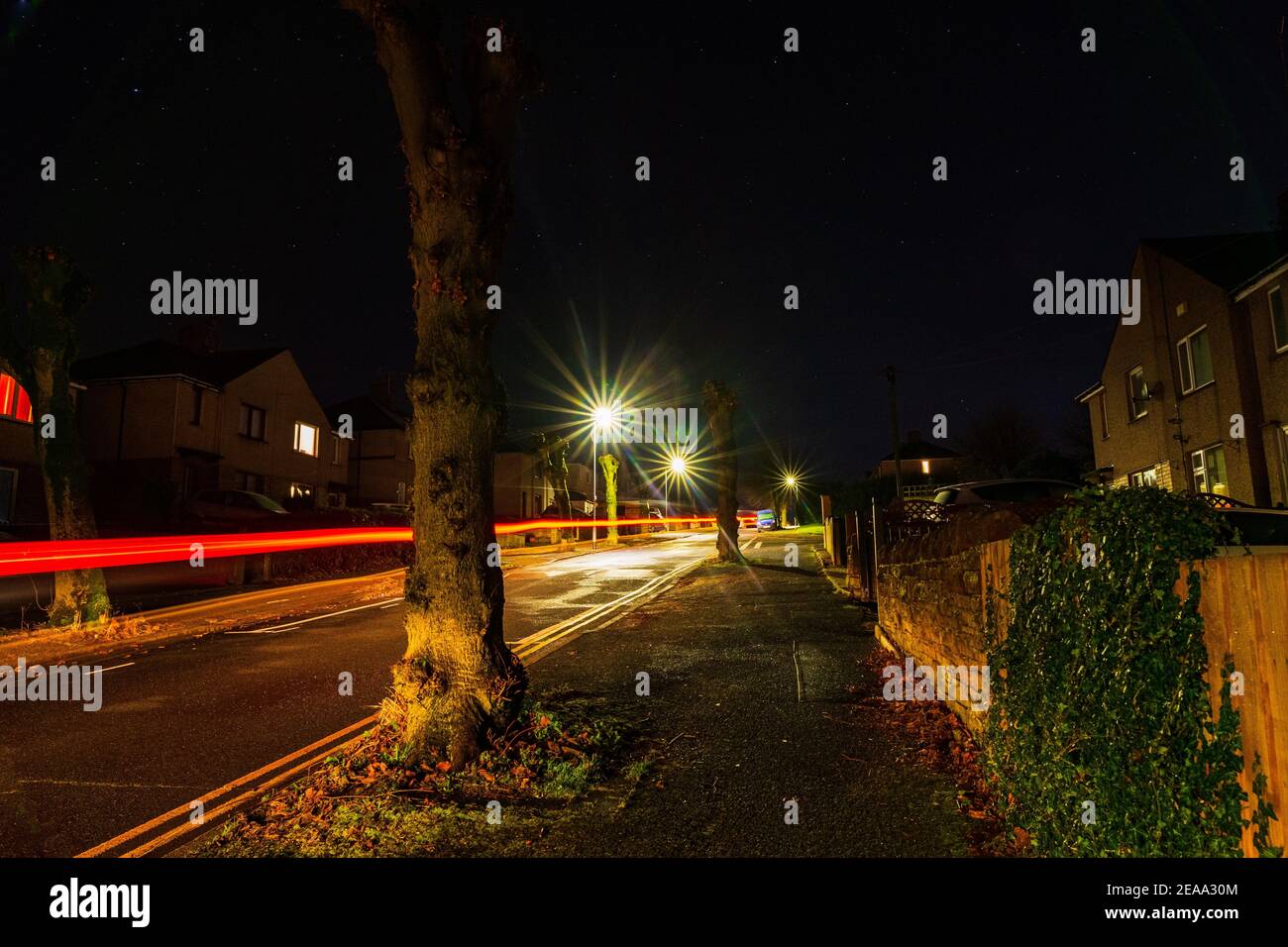 Luci di strada e sentieri per auto in una notte buia in Penrith Foto Stock