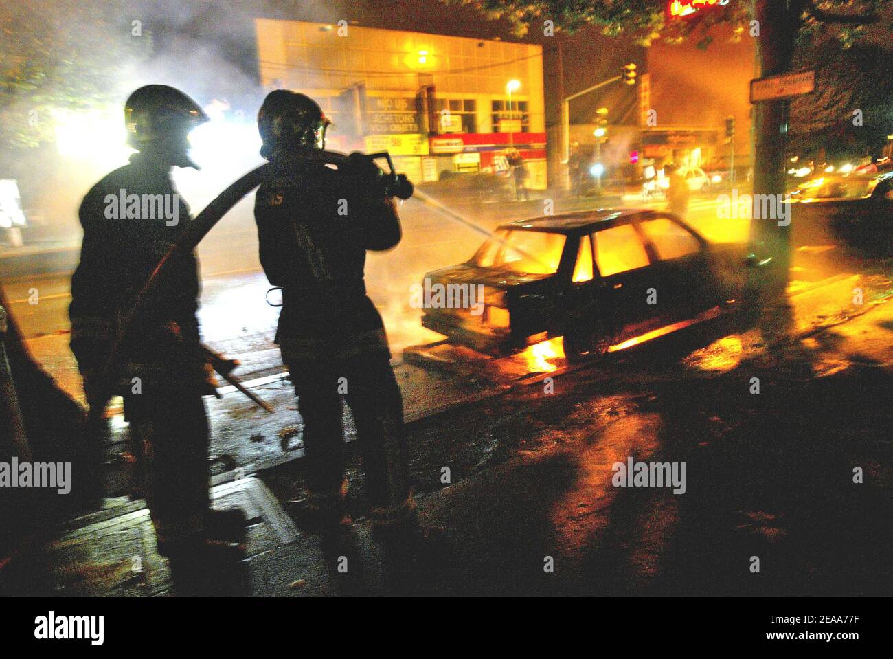 I vigili del fuoco cercano di spegnere un'auto che è stata messa in fuoco durante le rivolte nel sobborgo di Parigi di Bobigny il 2 novembre 2005. La polizia si scontrò con giovani arrabbiati dopo la morte per elettrocuzione, avvenuta il 27 ottobre, di due ragazzi che cercavano di fuggire dalla polizia. Foto di Mehdi Taamallah/ABACAPRESS.COM Foto Stock