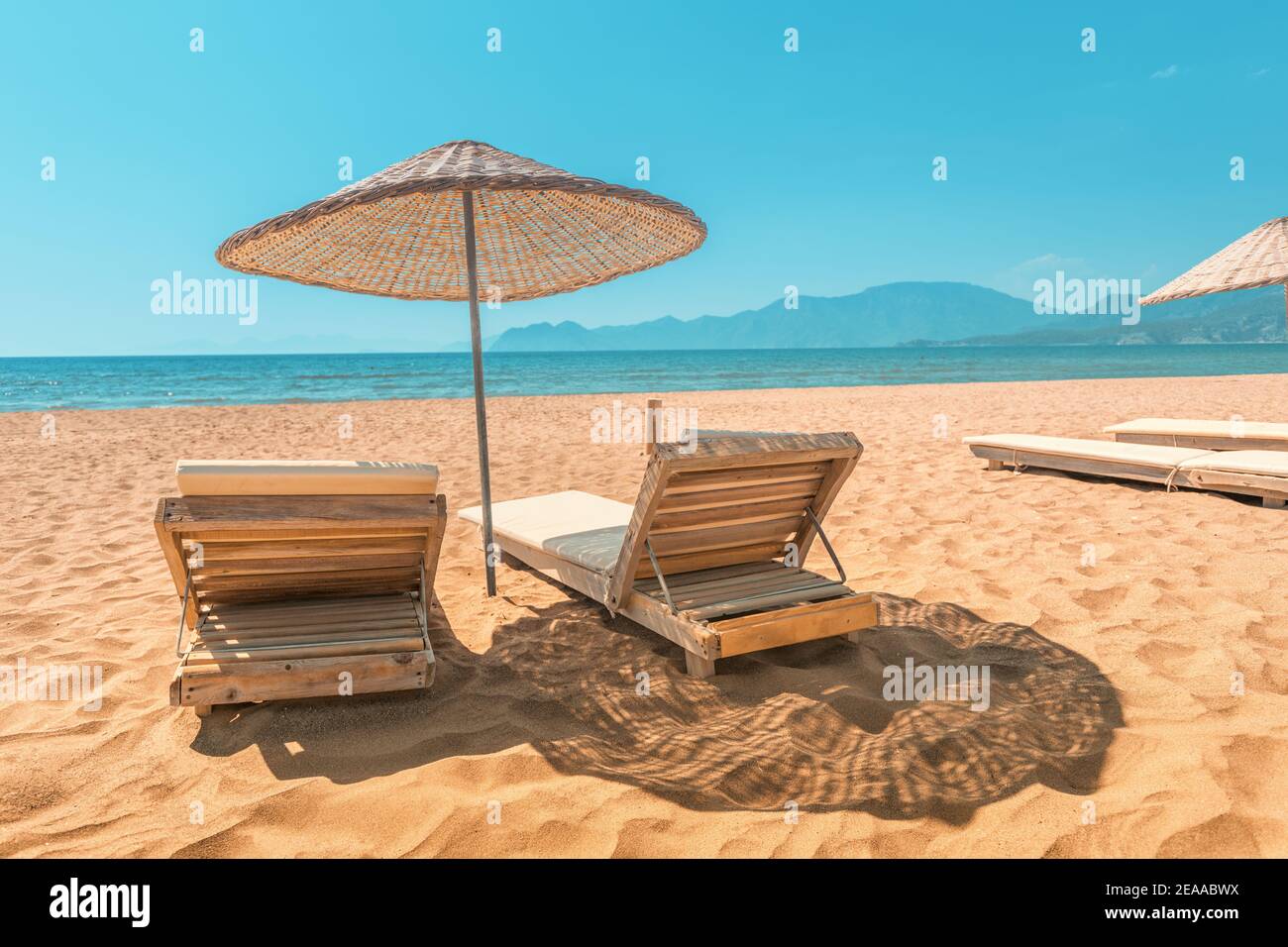 Lettino e ombrellone su una spiaggia di sabbia vuota in bassa stagione o al  mattino presto. Paradiso del mare e dell'oceano e concetto di vacanza Foto  stock - Alamy