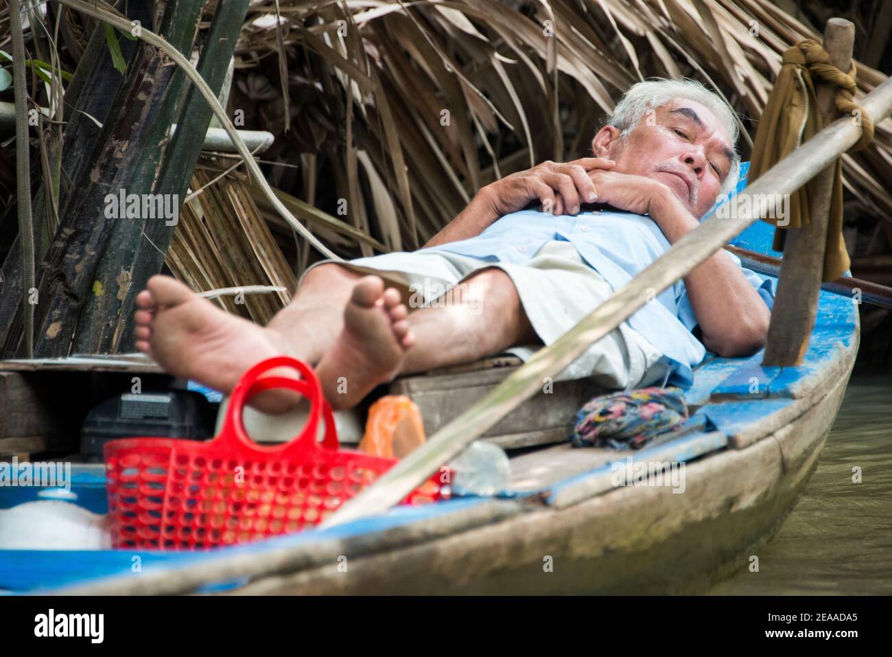 Vietnamita mentre si riposa sulla barca, Delta del Mekong, Vietnam Foto Stock