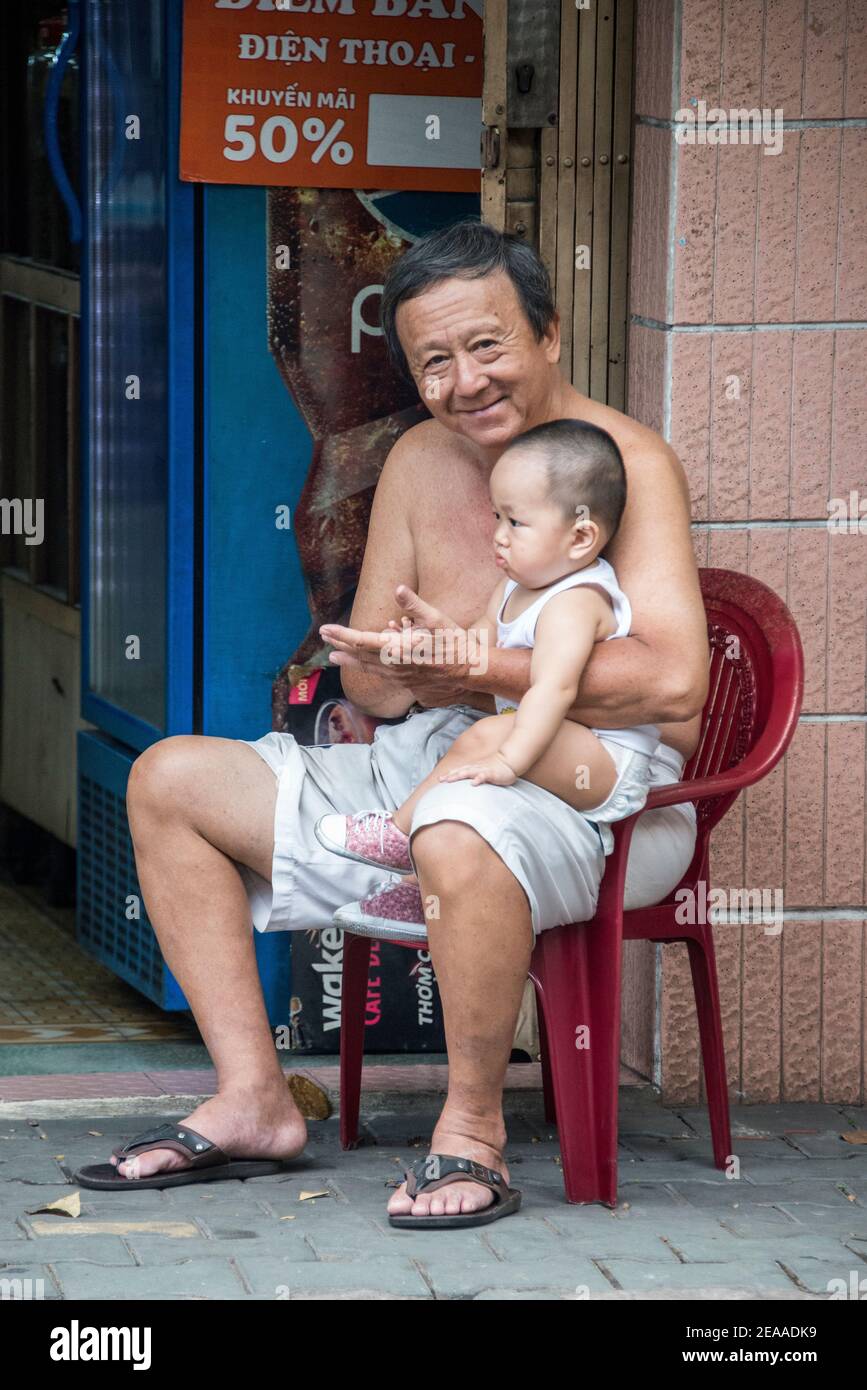 Padre con figlio seduto sulla strada, Vietnam Foto Stock