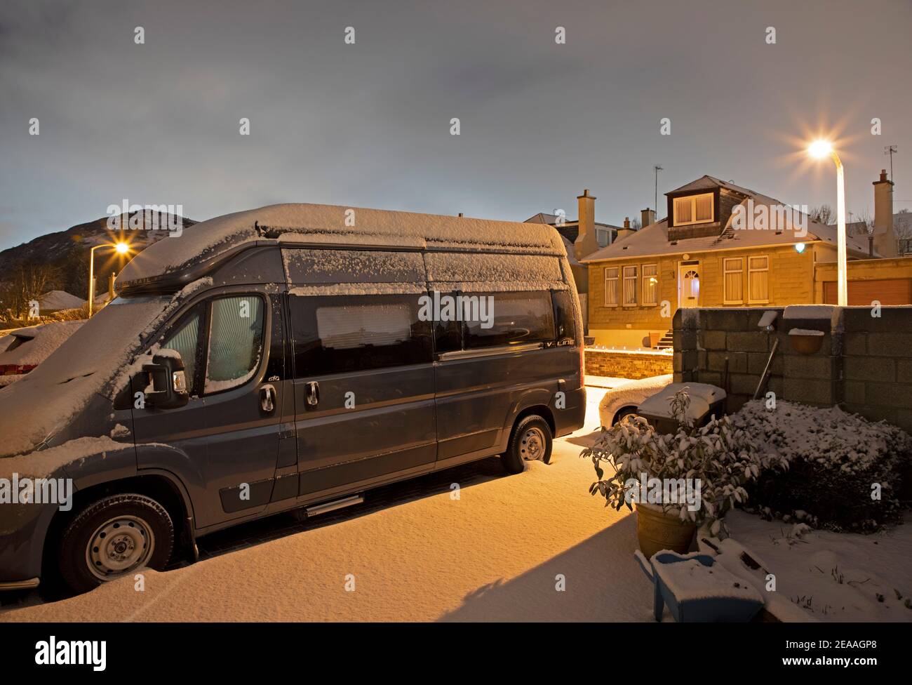 Edimburgo, Scozia, Regno Unito. 8 febbraio 2021. Neve pesante che cade a est della città, con più attesa di notte e verso domani. Camper seduto al minimo nel vialetto a causa della pandemia di Covid-19 e Arthur's Seat in background. Foto Stock