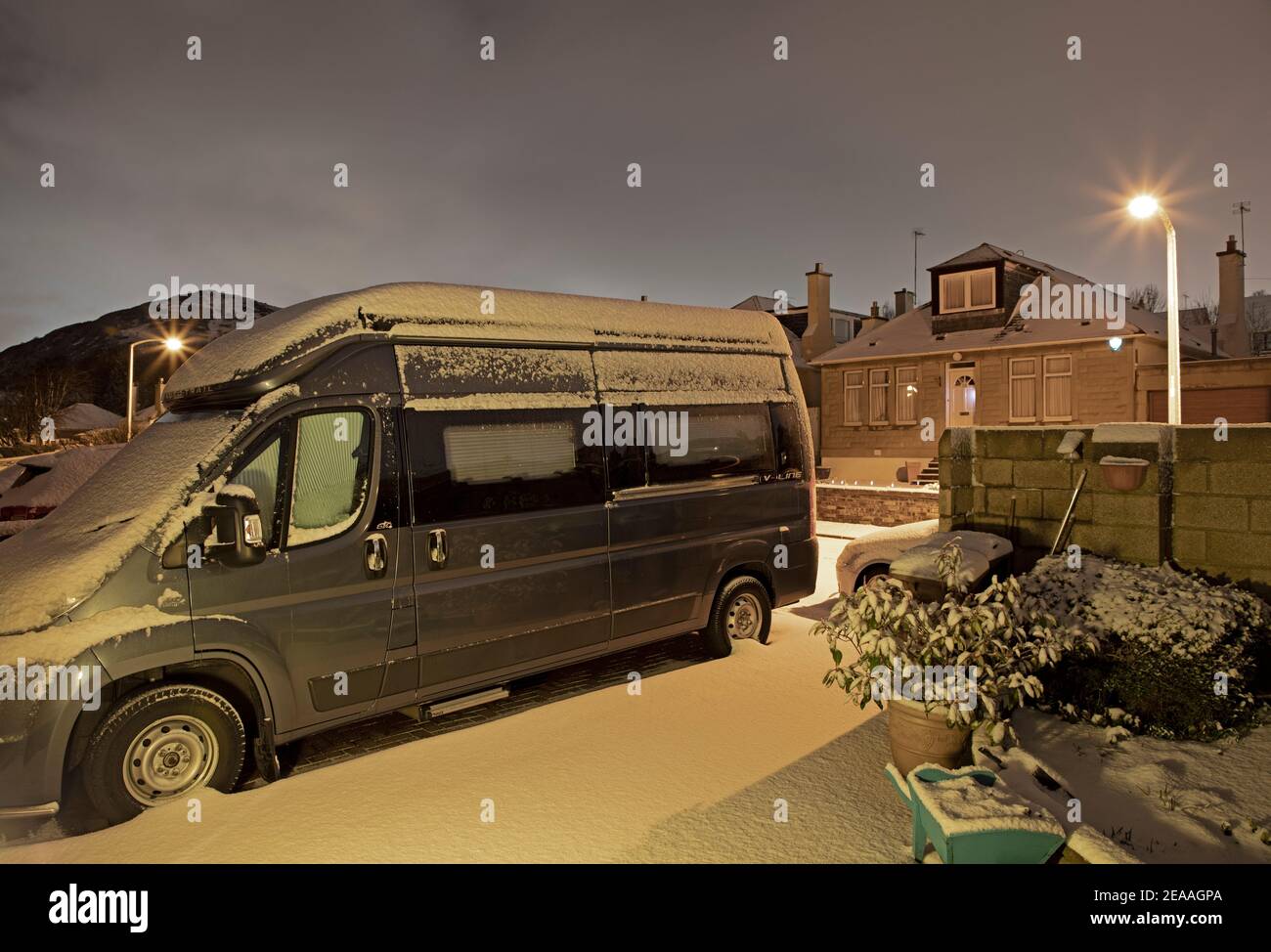 Edimburgo, Scozia, Regno Unito. 8 febbraio 2021. Neve pesante che cade a est della città, con più attesa di notte e verso domani. Camper seduto al minimo nel vialetto a causa della pandemia di Covid-19 e Arthur's Seat in background. Foto Stock