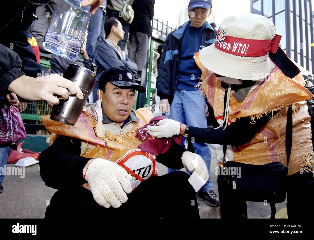 Gli agricoltori sudcoreani ricevono assistenza medica dopo uno scontro con la polizia di Hong Kong al di fuori del Centro Convegni di Hong Kong, dove i delegati si riunono alla sesta Conferenza ministeriale dell'Organizzazione Mondiale del Commercio il 17 dicembre 2005. I coreani del sud hanno b Foto Stock