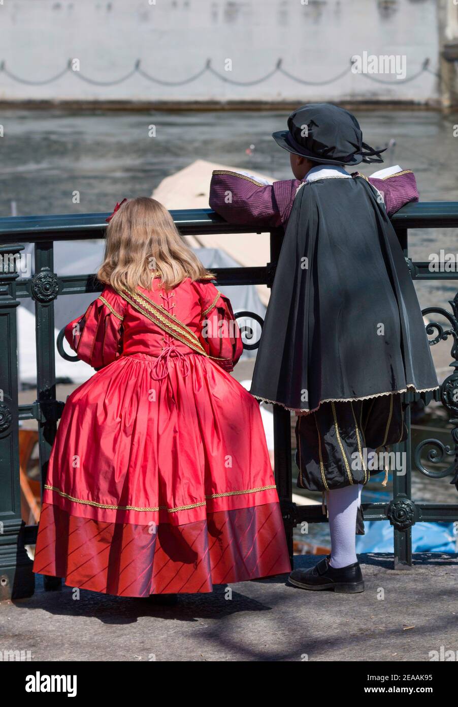 Ragazzini e ragazzini dalla schiena vestiti abiti tradizionali barocchi per sfilata sechselauten guardando in lontananza Foto Stock