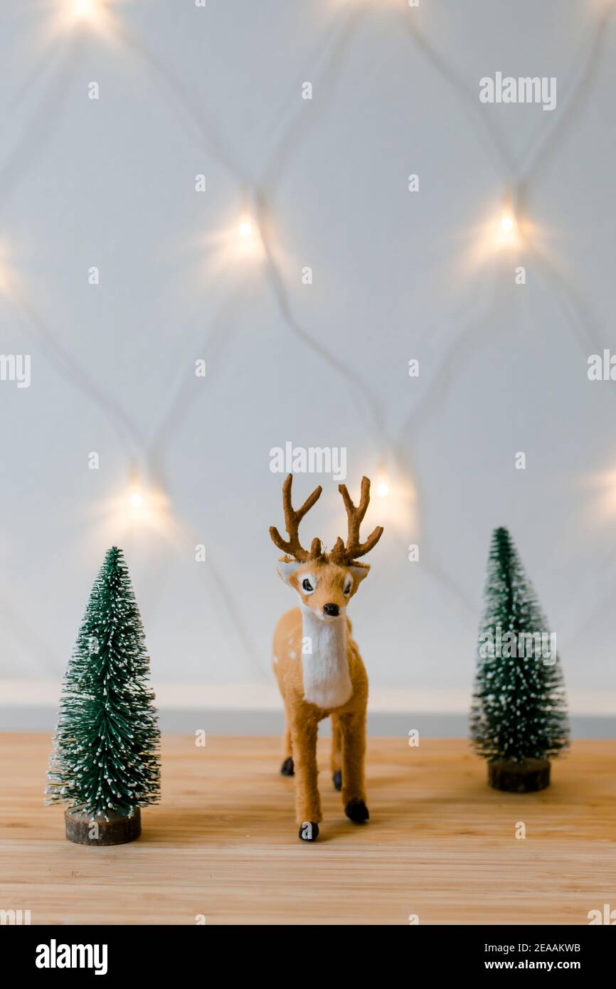 Decorazione di Natale, piccolo cervo peluche tra due alberi di Natale luci fata, umore di Natale, Foto Stock