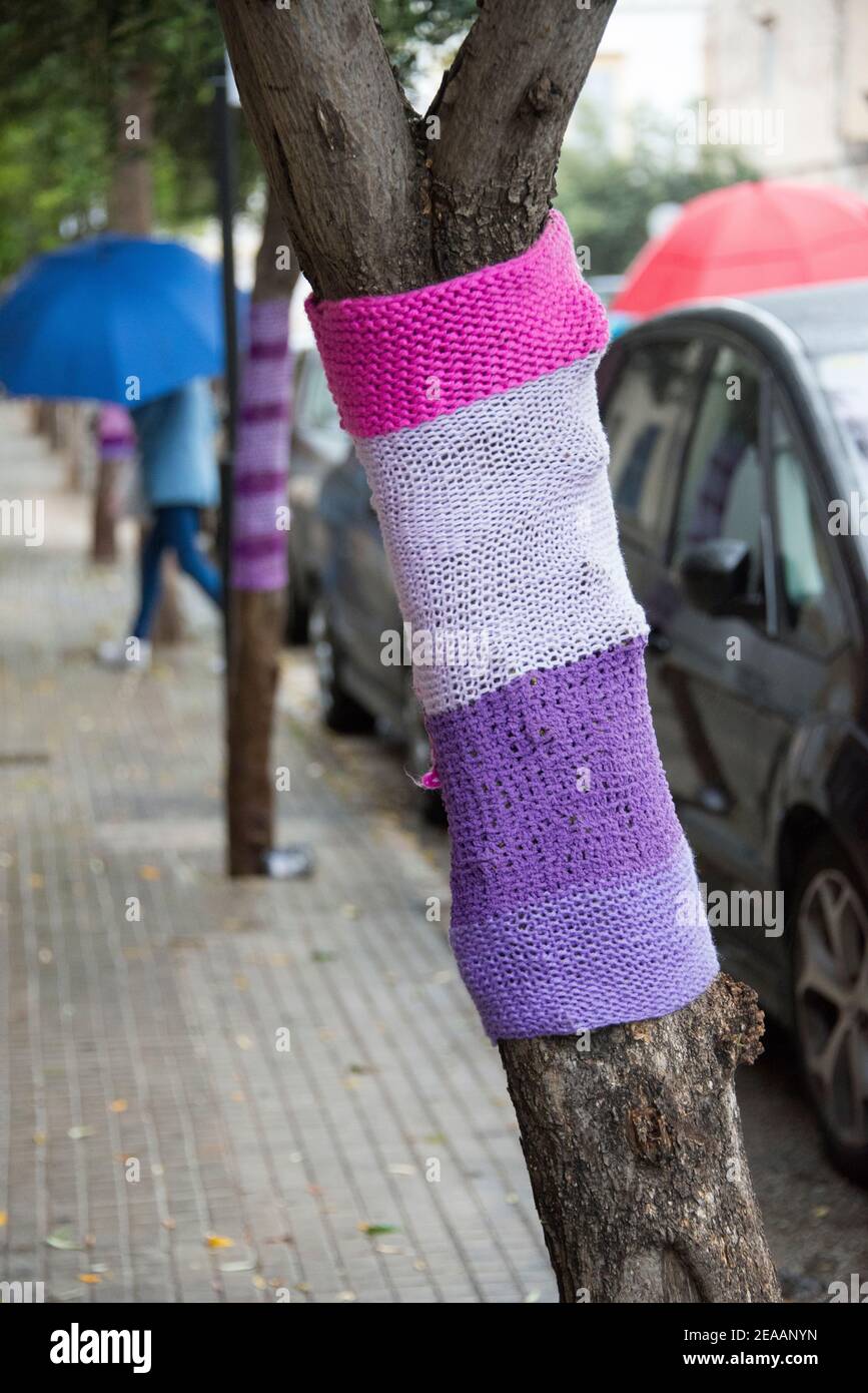 Tronco di albero lavorato a maglia con lana sul lato del strada Foto Stock