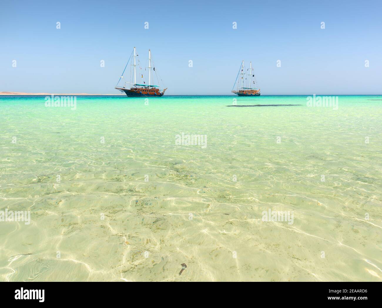 Due barche a vela in mare turchese sotto la luce del sole Foto Stock